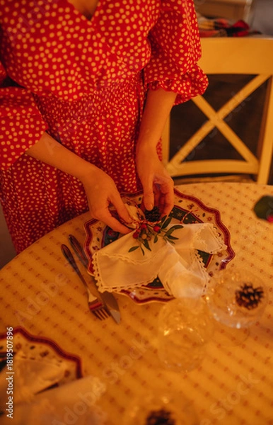 Obraz the hand of a woman setting the table for Christmas dinner