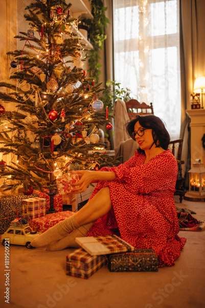 Obraz a woman with gifts under the Christmas tree