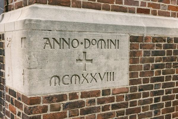 Fototapeta Historic stone inscription on a brick building from the year 1928 in a city setting