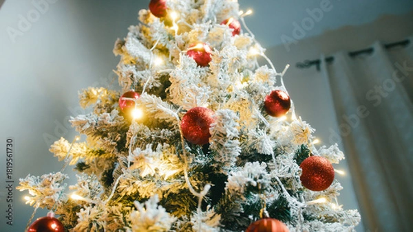 Fototapeta Christmas tree with red lights and white snowy branches tilt up