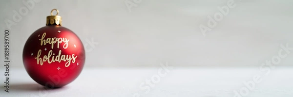 Fototapeta Banner Simple red ball ornament and handwritten “Happy Holidays”, clean Scandinavian design