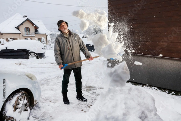 Obraz Man is removing snow after the snowfall.