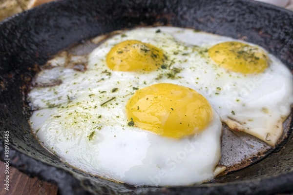 Obraz appetizing fried eggs in an old frying pan