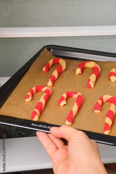 Fototapeta Step-by-step preparation of Candy Cane shortbread cookies in Christmas decor on a light concrete background. Merry Christmas!