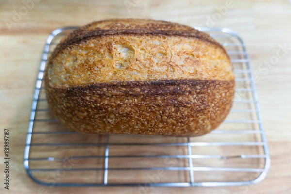 Fototapeta Freshly baked homemade loaf of wheat bread and sliced butter on a wooden table for a healthy breakfast meal