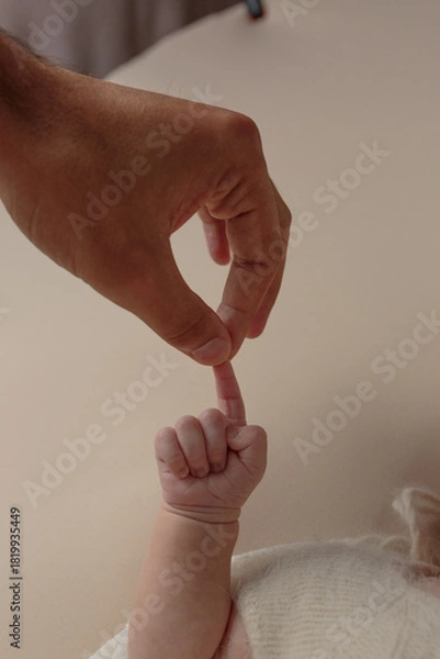 Fototapeta A Tender First Touch Between Parent and Newborn