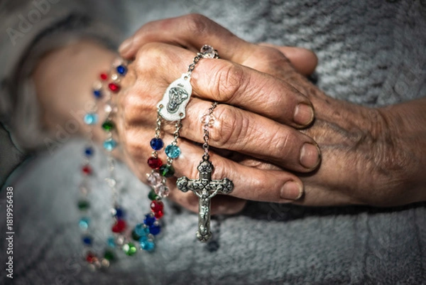 Fototapeta Elderly hands clasped together, adorned with colorful rosary beads, symbolizing faith and family, representing the passage of time and the bond between generations