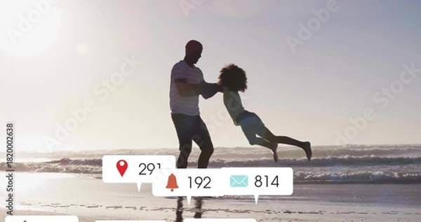 Obraz Swinging father in striped shirt holding daughter in light shorts at beach, with icons 29,192,814
