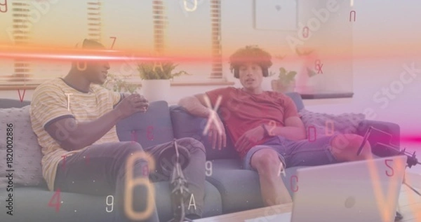 Obraz Holding mug, men in striped and red shirts leaning on gray-sofa in home lounge with laptop-mic