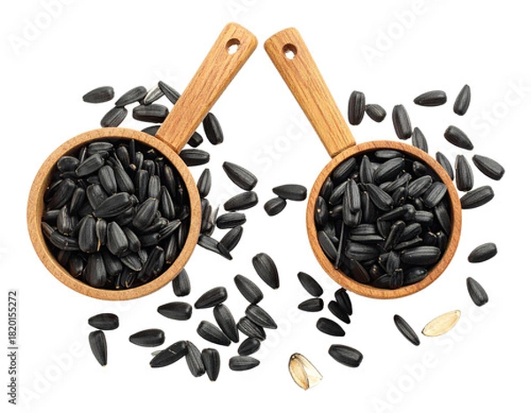 Fototapeta Two wooden scoops of dark seeds surrounded by a scattering of the same