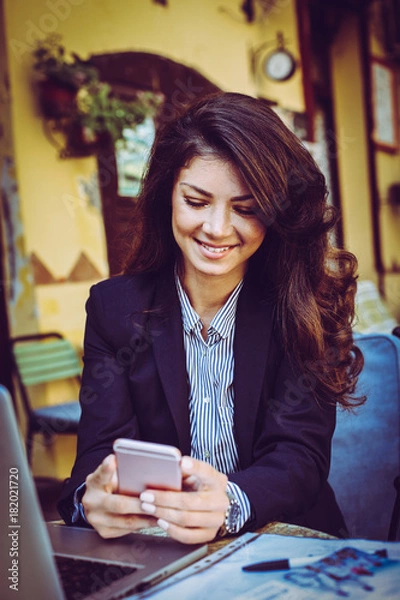 Fototapeta Business woman sitting at cafe using smart phone.