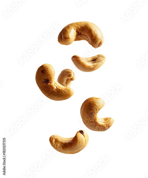 Fototapeta Toasted cashews floating mid-air on a plain backdrop