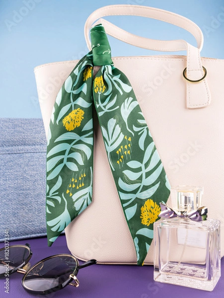 Obraz Close-up of a silk ribbon bow with a tropical leaf pattern on a white  leather bag