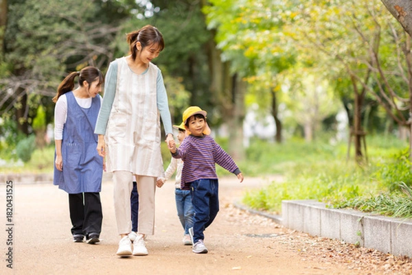 Obraz 手を繋いで歩く保育士と園児