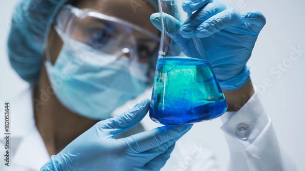 Fototapeta Researcher watching chemical reaction after adding test material into flask