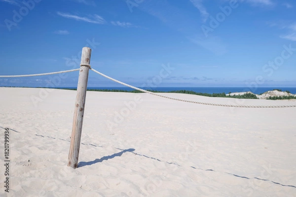 Obraz Fencing of the dune area. A protective barrier constructed of a round wooden post and ropes. Designating a no-cross zone. Dunes. Baltic Sea. Leba, Poland.