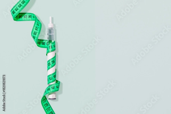 Fototapeta Slimming Injection Pen Wrapped With Measuring Tape On Pastel Background With Copy Space. Concept Of Medical Weight Loss, Beauty Trends, Body Goals, Aesthetic Treatments And Wellness Industry Marketing