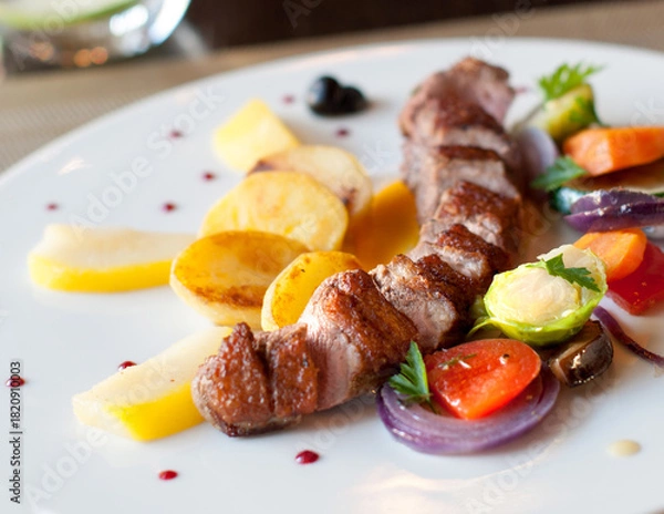 Obraz Grilled pork loin with vegetables on a plate in restaurant