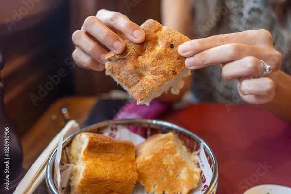 Obraz Woman Breaking Fresh Bread at Table