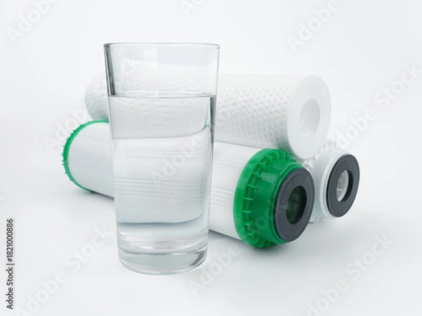 Fototapeta Set three of cartridges for water filter with clear glass of water. Concept of water treatment technology. filter cartridges to domestic water treatment systems. 