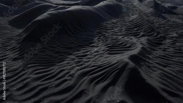Obraz Close-up of rippled dark sand formations, with varying wave-like ridges and soft shadows