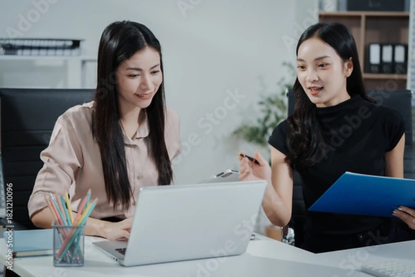 Fototapeta Asian businesswoman working at desk, analyzing data, reviewing reports, providing consultation, strategizing marketing, finance, and accounting tasks, focused, professional, organized, using laptop