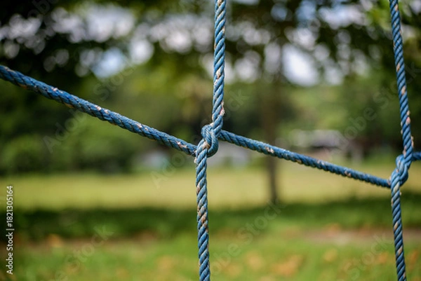 Fototapeta Closeup of blue ropes tied in a knot at a park playground setting