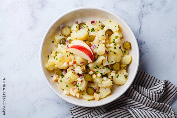 Obraz Traditional German potato salad with pickles, onions and apple.