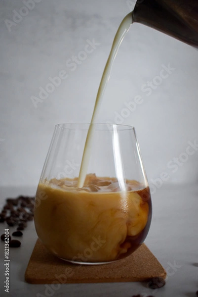 Obraz Preparing iced coffee, pouring cold milk