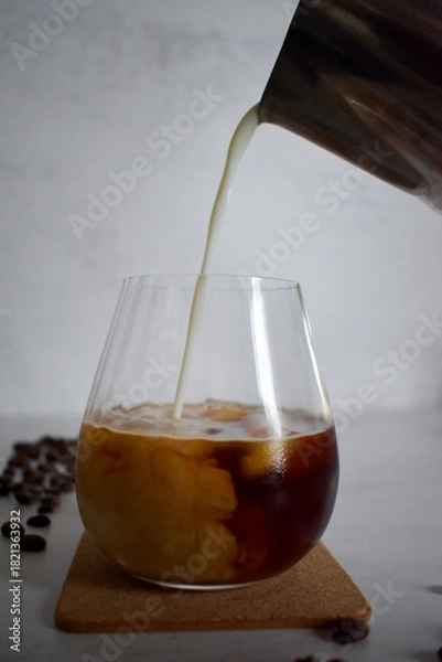 Obraz Preparing iced coffee, pouring cold milk