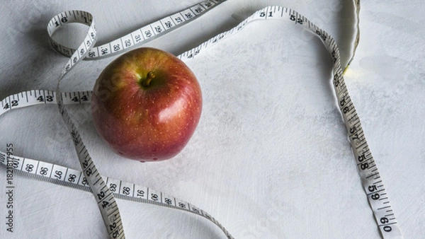 Obraz Red Apple and Measuring Tape on White Background. Concept for Diet, Weight Loss, Healthy Eating and Wellness.