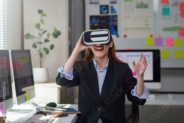 Fototapeta Woman playing or working in virtual reality headset in office. Exploring metaverse or future technology concept
