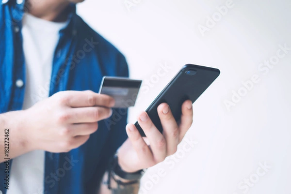 Fototapeta Man with smartphone and credit card