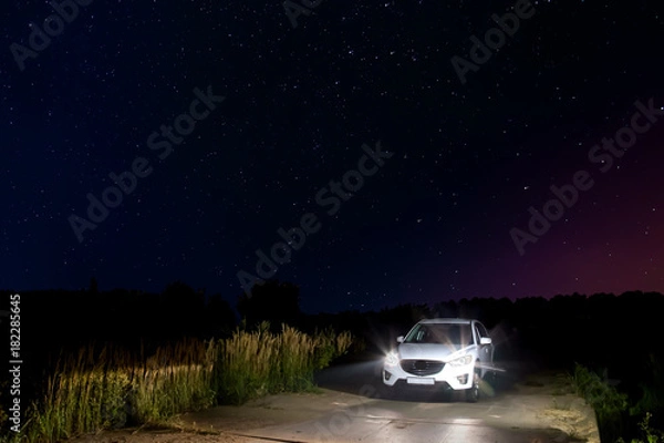 Obraz car with headlights against the star sky