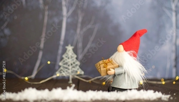Fototapeta Gnome with gift and tree in winter forest.