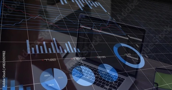 Obraz Displaying centered laptop showing blue charts at office desk, with keyboard, phone, green notebook