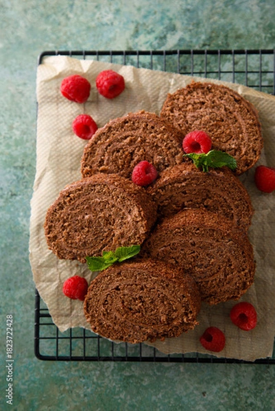Fototapeta Dark chocolate swiss roll with raspberry
