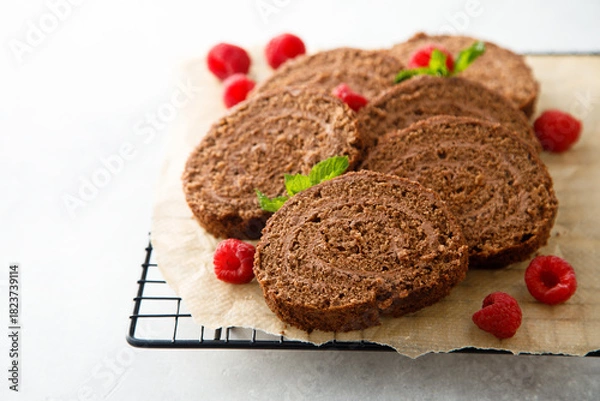 Fototapeta Dark chocolate swiss roll with raspberry