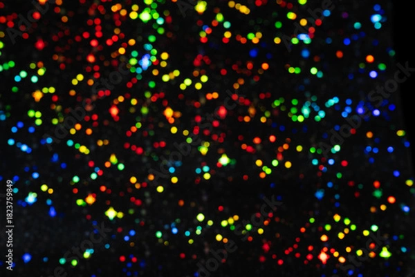 Fototapeta Black background with colorful bokeh lights, vibrant, festive, and atmospheric mood. Defocused multicolored glowing circles backdrop for design.
