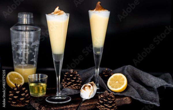 Fototapeta Lemon meringue cocktail with toasted topping in tall flute glasses