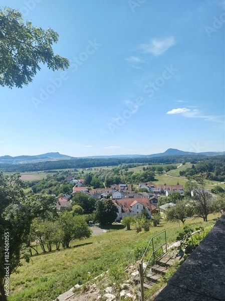 Obraz Beautiful view of the village Aach in the countyside of Germany on a sunny day with a blue sky and mountains in the distance