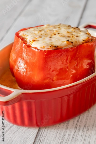 Fototapeta Single red bell pepper baked with bolognese filling and melted mozzarella topping