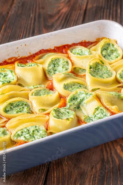 Obraz Golden baked lumaconi filled with ricotta and spinach resting in rich tomato sauce