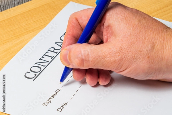 Fototapeta Signing a contract, businessman puts signature on document