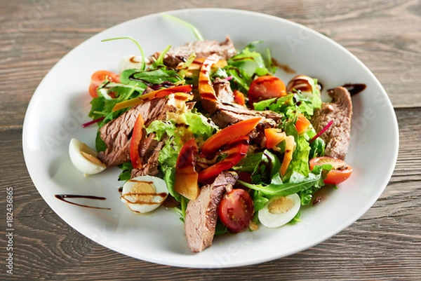 Obraz Horizontal close up shot of delicious freshly made salad with meat eggs and vegetables on the wooden table eating food lunch dinner meal gourmet mix chopped healthy edibles.