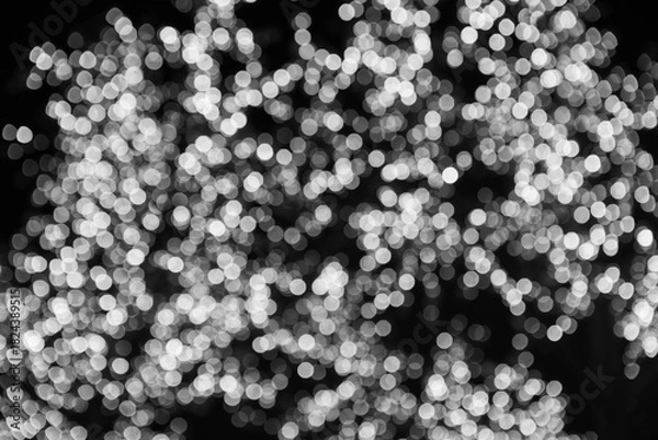 Obraz Soft white bokeh lights creating an abstract, festive glow against a dark background.