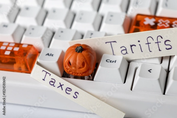 Fototapeta white and orange keycaps, next to "taxes" and "tariffs" labels. economic policy and halloween.