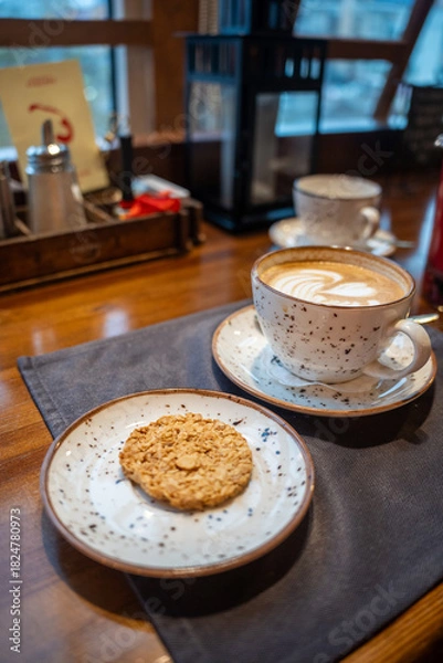 Obraz Coffee and cookie on cafe table. Cozy break time.