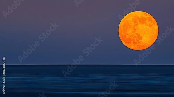 Fototapeta A vivid orange moon hangs over a still ocean at twilight.