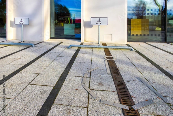 Fototapeta Accessible parking spaces with wheelchair symbols in front of modern building entrance